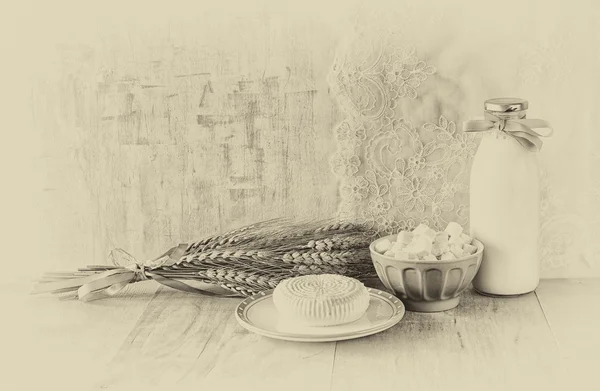 Greek cheese , bulgarian cheese and milk on wooden table over wooden textured background. black and white photo. Symbols of jewish holiday - Shavuot — Stock Photo, Image
