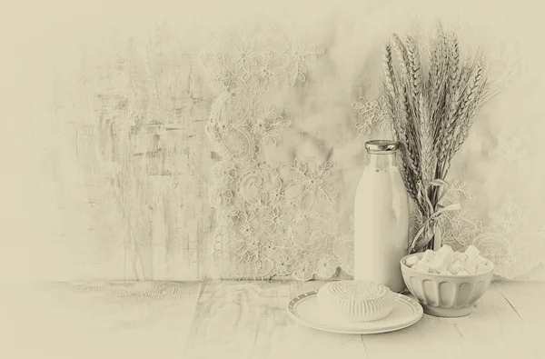 Griechischer Käse, bulgarischer Käse und Milch auf einem Holztisch vor hölzernem Hintergrund. Schwarz-Weiß-Foto. Symbole des jüdischen Feiertags - shavuot — Stockfoto