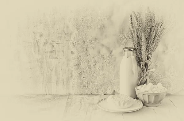 Griekse kaas, Bulgaarse kaas en melk op houten tafel over houten gestructureerde achtergrond. zwart-wit foto. Symbolen van Joodse vakantie - Sjavoeot (Wekenfeest) Stockfoto