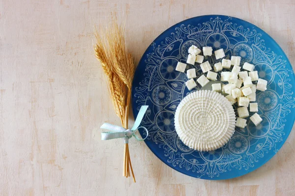 Pemandangan atas keju Yunani dan keju bulgaria di atas meja kayu di atas latar belakang bertekstur kayu. Simbol liburan Yahudi Shavuot — Stok Foto