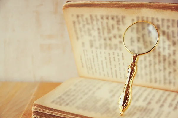 Macro imagen de lupa sobre libro abierto antiguo . —  Fotos de Stock