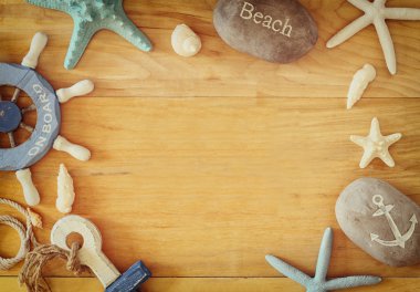 Deniz topluluğu ve plaj nesneleri ahşap arka plan üzerinde bir çerçeve oluşturma,