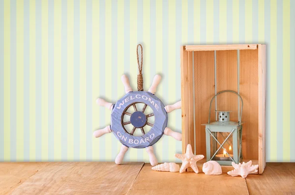 Oude nautische wiel, anker en schelpen op houten tafel over retro achtergrond van hout — Stockfoto