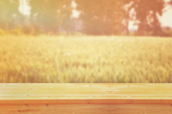 Dřevěný stůl před pšeničným polem při západu slunce. Ready for product display montages — Stock fotografie