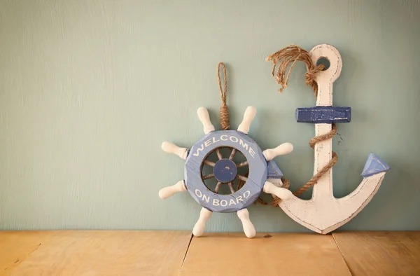 Velha roda de madeira náutica e âncora em mesa de madeira sobre fundo de aqua de madeira — Fotografia de Stock