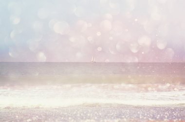Arka plan bulanık plaj, dalgalar deniz ve yelken tekne ufuktan bokeh ışıklar, vintage filtre ile.