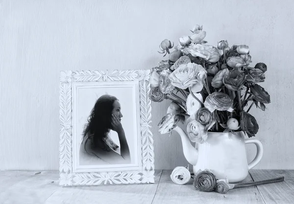 Літній букет квітів і вікторіанська рамка з вінтажним портретом молодої жінки на дерев'яному столі. чорно-біле зображення з текстурованим накладанням — стокове фото