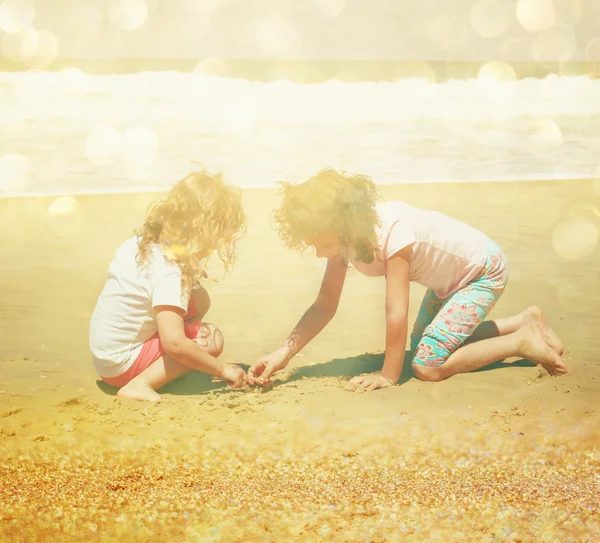 Miúdo feliz bonito (menina) brincando na praia. imagem tonificada com sobreposição de brilho — Fotografia de Stock