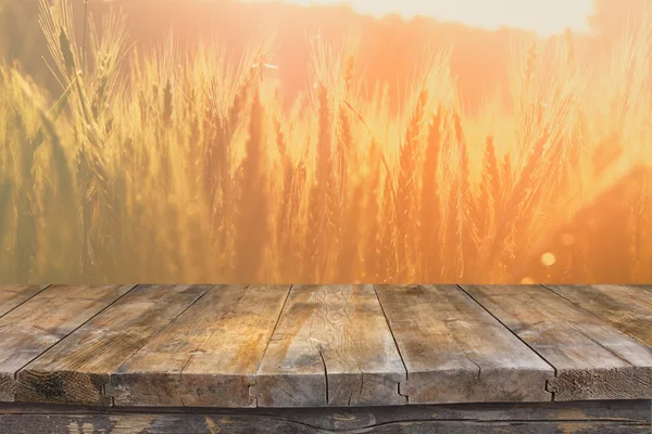 Mesa de madera delante del campo de trigo a la luz del atardecer. Listo para montajes de exhibición de productos —  Fotos de Stock