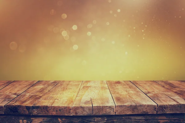 Деревянный стол в сельской местности перед блестящими серебряными и золотыми яркими боке огнями — стоковое фото
