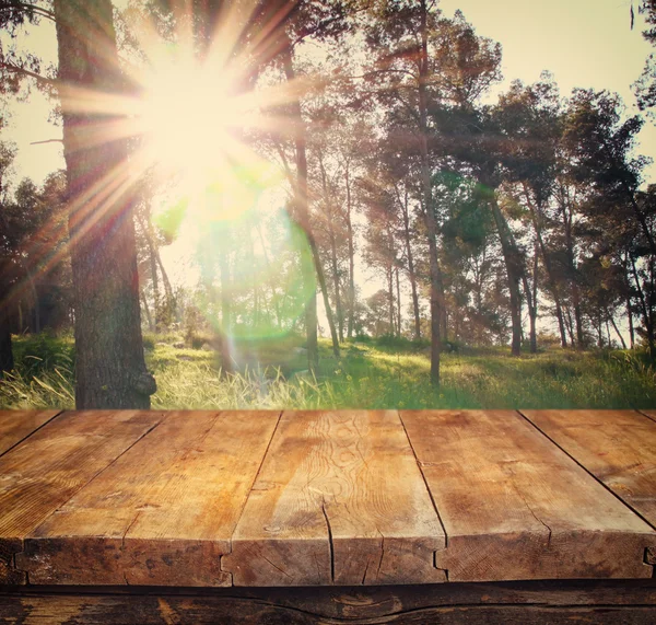 Wood board table in front of summer landscape with lens flare. — Stock Photo, Image