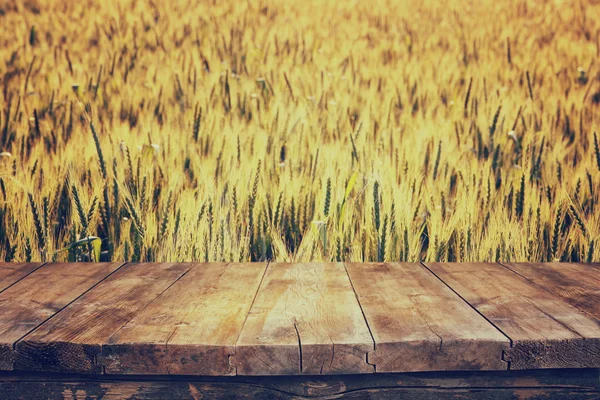 夕暮れ時の小麦畑の前の木の板。製品表示用モンタージュの準備 — ストック写真