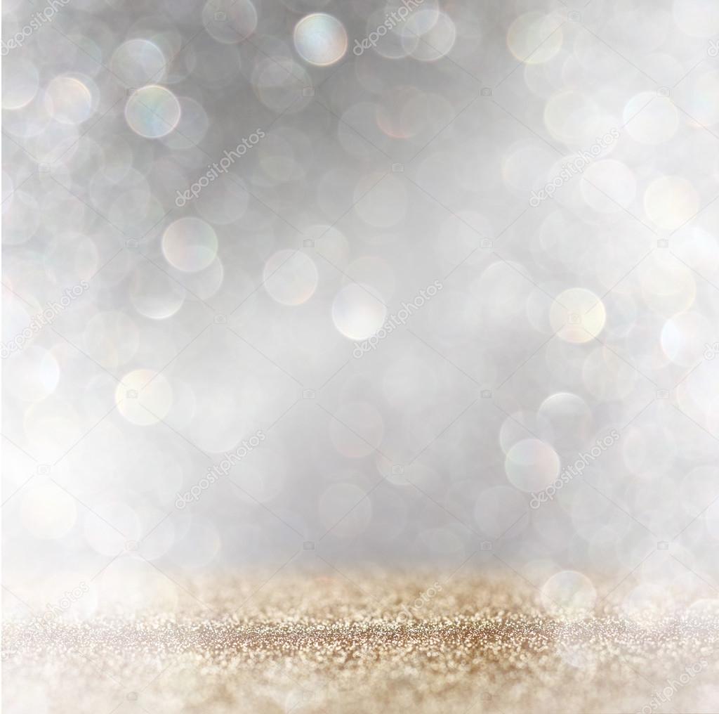 Abstract image of glitter vintage lights background with light burst . silver, gold and white. de-focused.