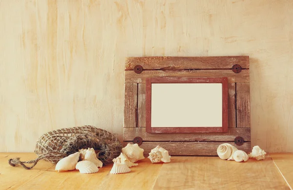 Oude nautische houten frame en natuurlijke schelpen op houten tafel — Stockfoto