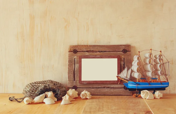 Starý námořní dřevěný rám, loď a přírodní mušle na dřevěný stůl — Stock fotografie