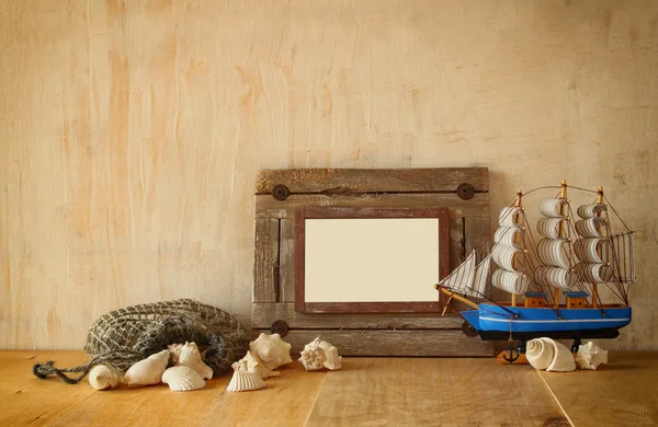 Oude nautische houten frame, boot en natuurlijke schelpen op houten tafel — Stockfoto