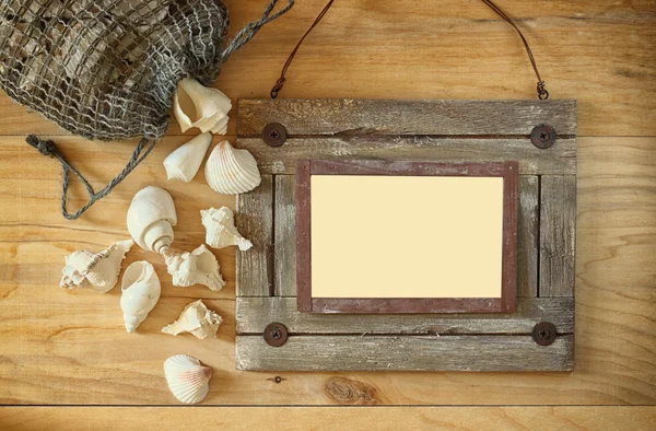 Top view of old nautical wooden frame and natural seashells on wooden table — Stock Photo, Image