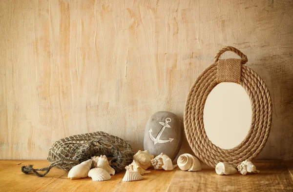 Винтажная морская рама из веревок и натуральных раковин на деревянном столе — стоковое фото