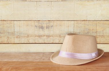 Ahşap masa ve ahşap arka plan üzerinde Fedora şapka