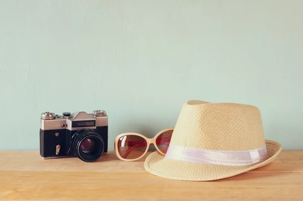 Cappello Fedora, occhiali da sole vecchia macchina fotografica d'epoca sopra tavolo di legno. concetto di relax o vacanza — Foto Stock