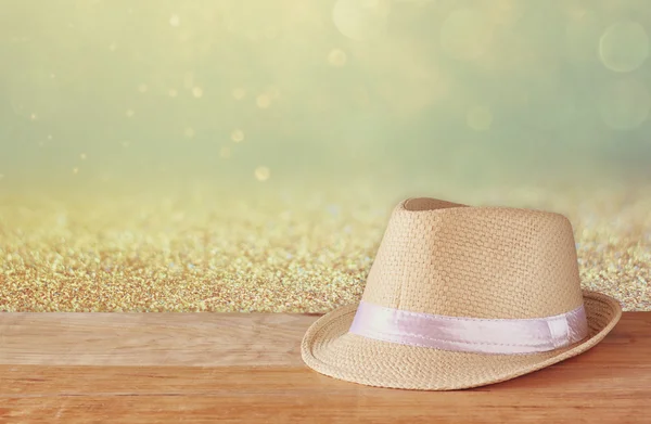 Шляпа Fedora на деревянном столе и блестящем фоне — стоковое фото