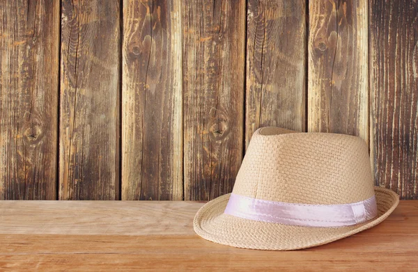 Fedora hoed over houten tafel en houten achtergrond — Stockfoto