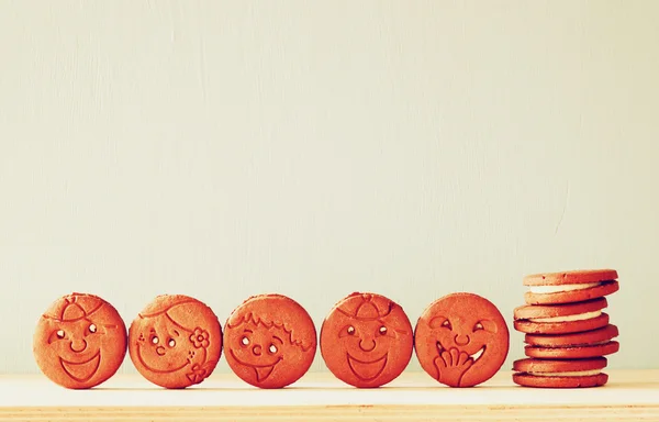 stock image Raw of cookies with smiley face over wooden table