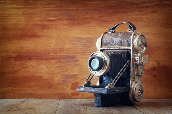 Vintage vecchia fotocamera decorativa su sfondo marrone in legno. spazio per il testo . — Foto Stock