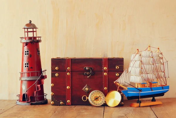 古色古香的罗盘、 老式灯塔、 木船和老胸部木制的桌子上 — 图库照片