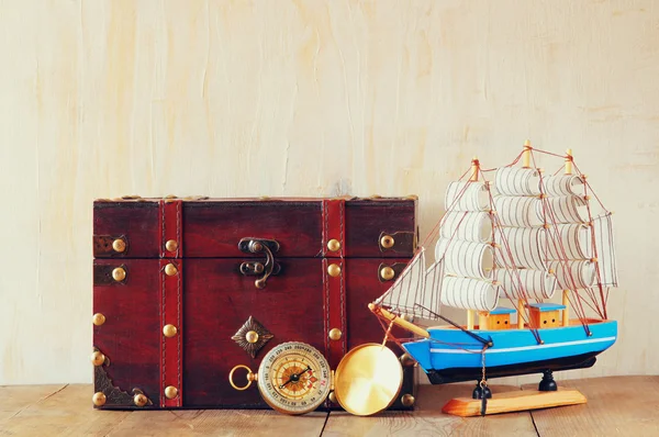 Antique compass, wooden boat and old chest  on wooden table — Stock Photo, Image