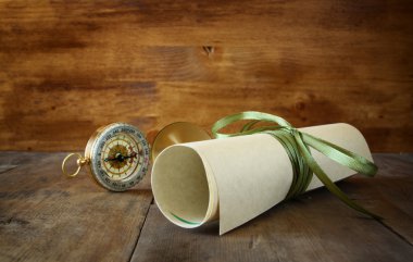 Ahşap masa üzerinde eski parşömen ve antika pusula