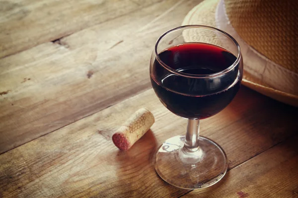 Copa de vino tinto y viejo libro sobre mesa de madera al atardecer estalló. vintage imagen filtrada — Foto de Stock