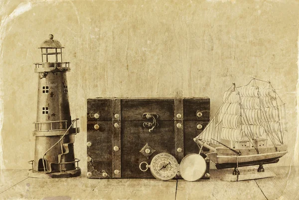 Bússola antiga, farol vintage, barco de madeira e peito velho na mesa de madeira. preto e branco estilo foto velha — Fotografia de Stock