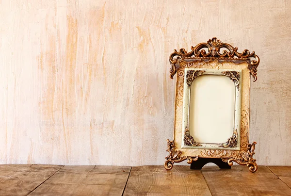 Image of victorian vintage antique classical frame on wooden table. filtered image — Stock Photo, Image