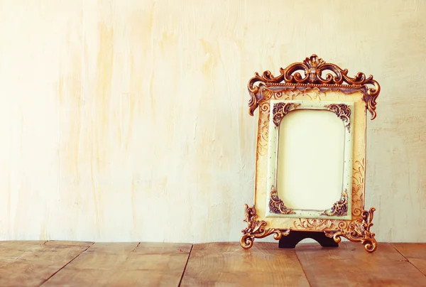 Image of victorian vintage antique classical frame on wooden table. filtered image — Stock Photo, Image