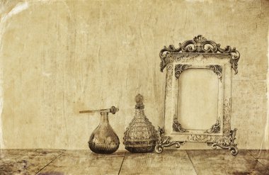 Victoria vintage antik klasik çerçeve ve parfüm bottels ahşap masa üzerinde görüntü. siyah beyaz eski stil fotoğraf
