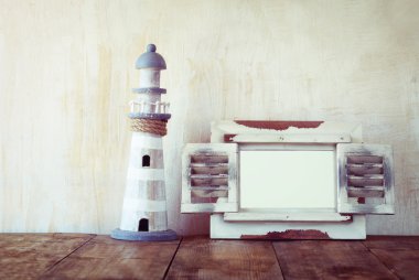 Eski vintage ahşap beyaz çerçeve ve ahşap masa deniz feneri. Vintage filtre uygulanan görüntü. Deniz yaşam tarzı kavramı
