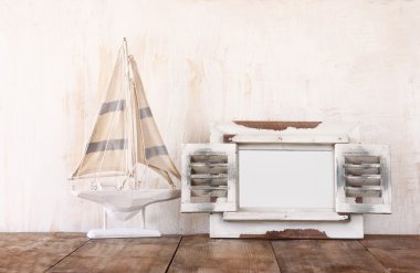 Eski vintage ahşap beyaz çerçeve ve yelkenli tekne ahşap masa üzerinde. Vintage filtre uygulanan görüntü. Deniz yaşam tarzı kavramı