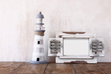 Eski vintage ahşap beyaz çerçeve ve ahşap masa deniz feneri. Vintage filtre uygulanan görüntü. Deniz yaşam tarzı kavramı