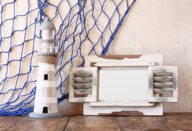 Eski vintage ahşap beyaz çerçeve ve ahşap masa deniz feneri. Vintage filtre uygulanan görüntü. Deniz yaşam tarzı kavramı