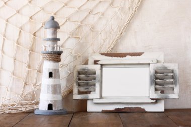 Eski vintage ahşap beyaz çerçeve ve ahşap masa deniz feneri. Vintage filtre uygulanan görüntü. Deniz yaşam tarzı kavramı