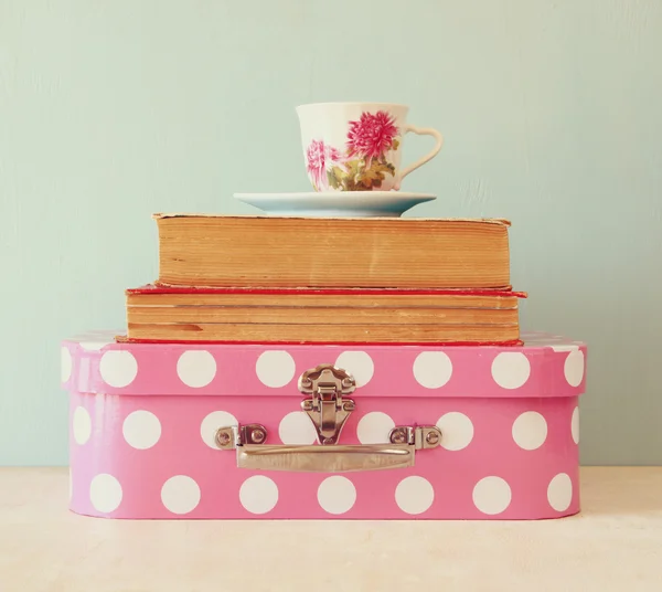 Stos starych walizkę, książek i filiżanki herbaty rocznika nad drewnianym stole. obraz w stylu retro — Zdjęcie stockowe