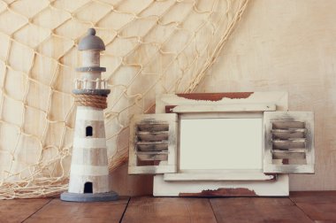 Eski vintage ahşap beyaz çerçeve ve ahşap masa deniz feneri. Vintage filtre uygulanan görüntü. Deniz yaşam tarzı kavramı