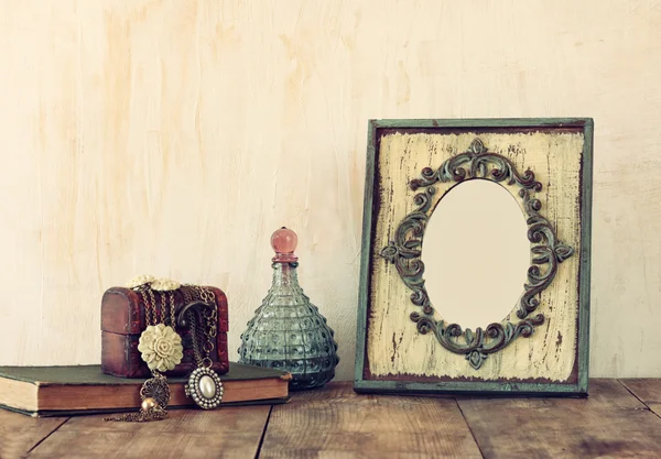 Afbeelding van Victoriaanse vintage antieke klassieke frame, juwelen en parfum flessen op houten tafel. gefilterde afbeelding — Stockfoto