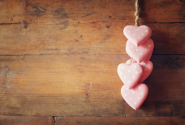 Pink wooden hearts over wooden background — Stock Photo, Image