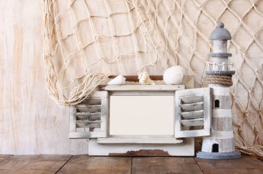 Eski vintage ahşap beyaz çerçeve ve ahşap masa deniz feneri. Vintage filtre uygulanan görüntü. Deniz yaşam tarzı kavramı