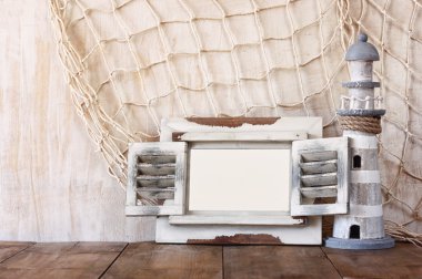 Eski vintage ahşap beyaz çerçeve ve ahşap masa deniz feneri. Vintage filtre uygulanan görüntü. Deniz yaşam tarzı kavramı