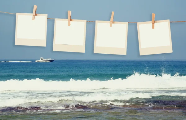 Gamla polaroid foto ramar hnaging på ett rep med beach bakgrund — Stockfoto