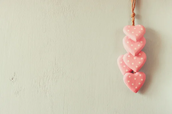 Corazones de madera rosa sobre fondo acuático de madera — Foto de Stock