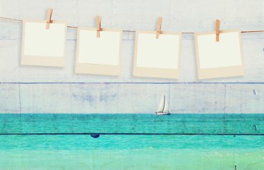 Yelkenli ahşap plakalar arka plan ve deniz ufukta, çift pozlama görüntü ile bir iple asılı eski polaroid fotoğraf çerçeveleri